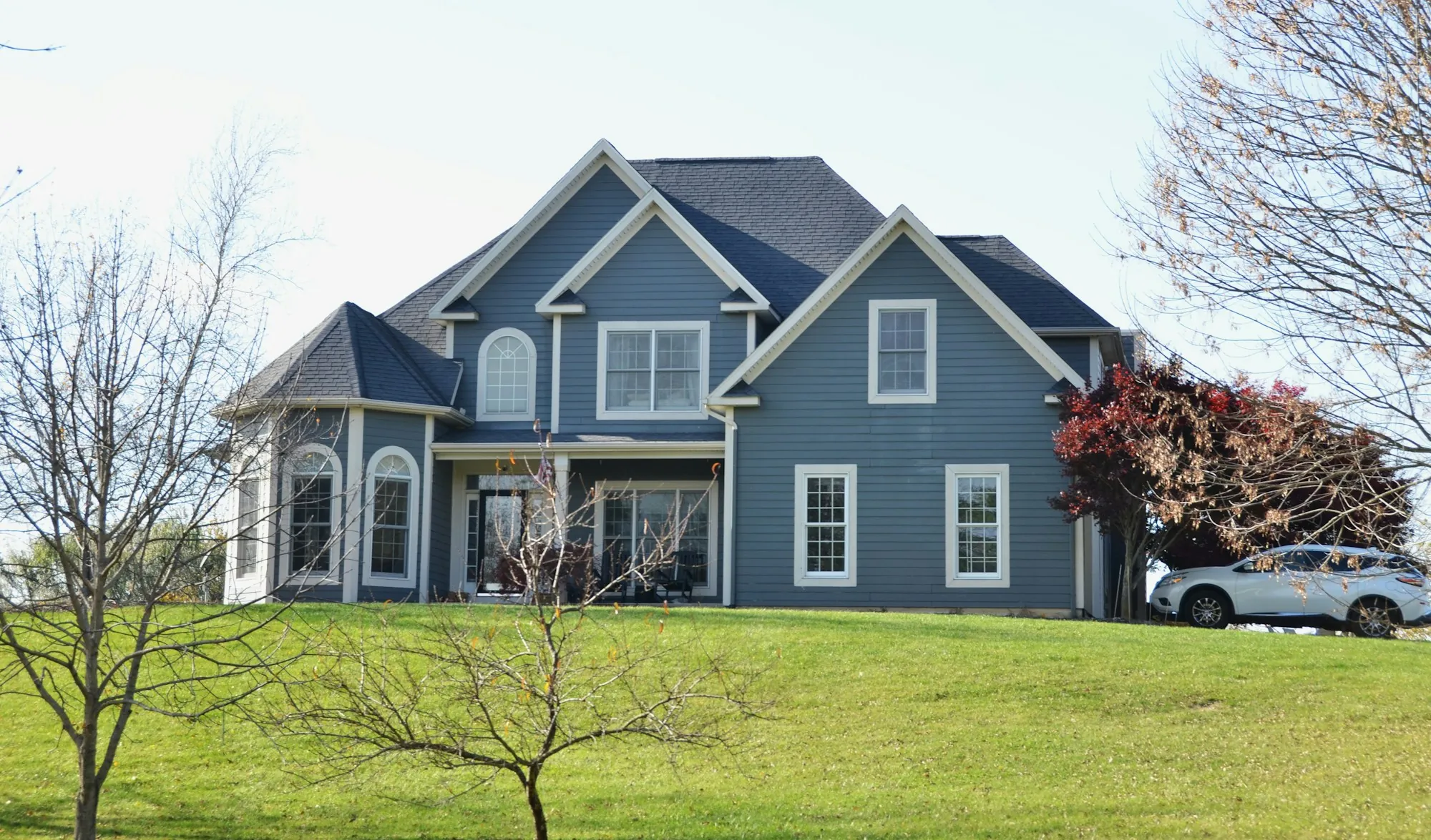 Blue two-story home with a large front lawn