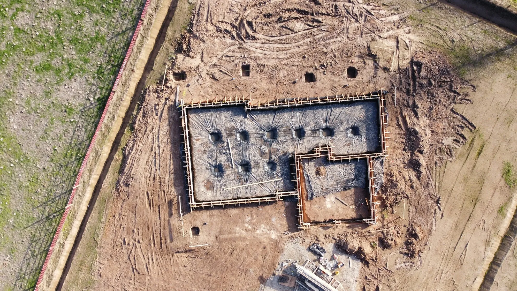Aerial view of a new home foundation on a cleared lot